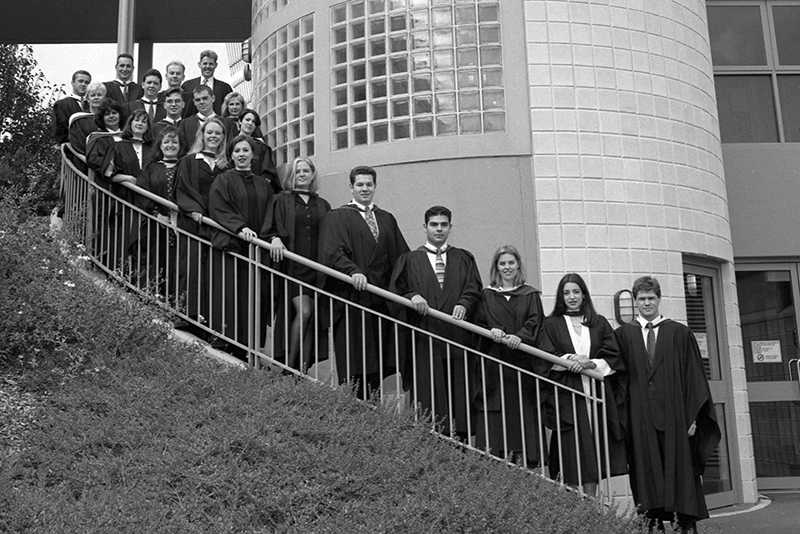 Inaugural graduates of Flinders Law in 1996 stand on staircase