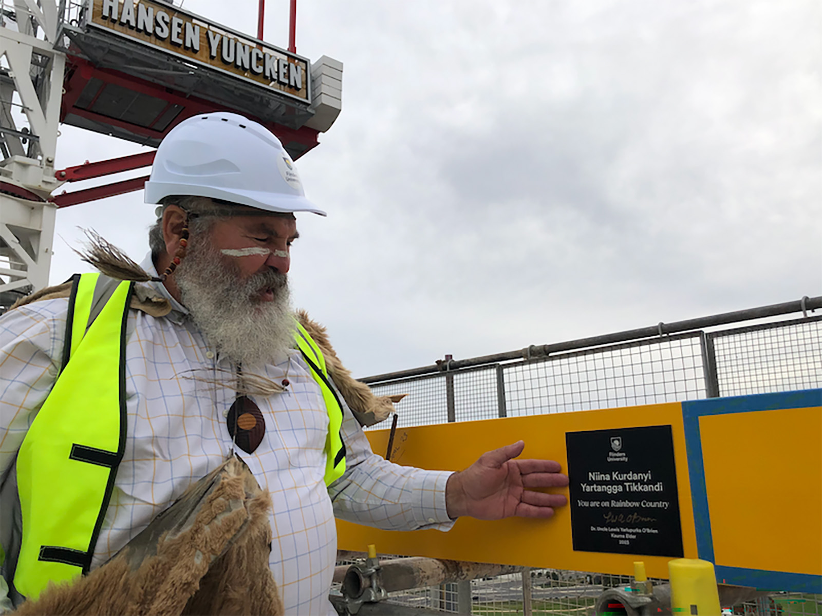 Uncle Mickey Kumatpi Marutya O'Brien unveils a plaque at the topping out ceremony