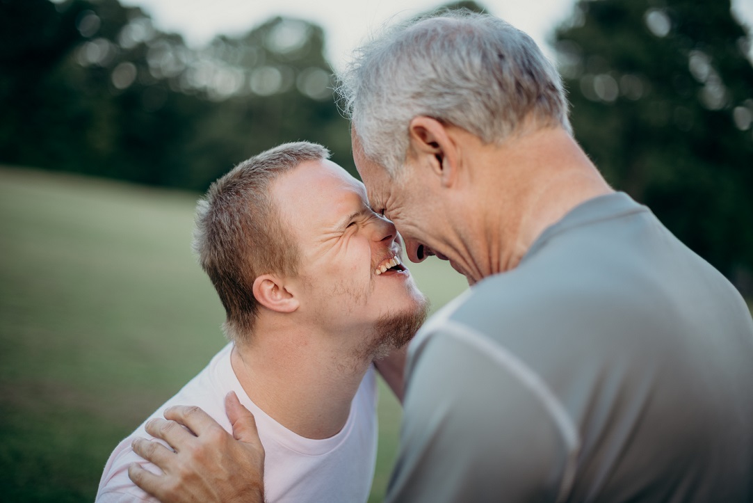 A man with Downs syndrome hugs his father