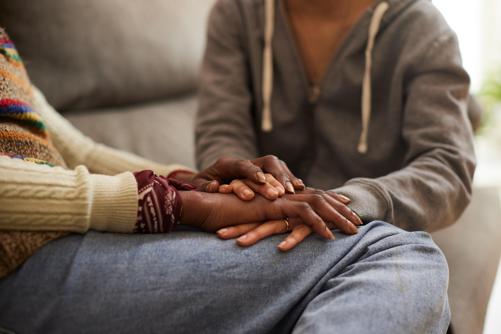 Daughter holding mother hands and comforting her - stock photo
