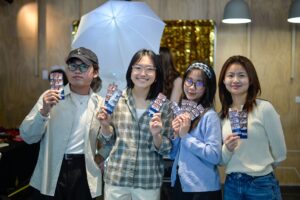 Flinders University international students holding up photobooth images