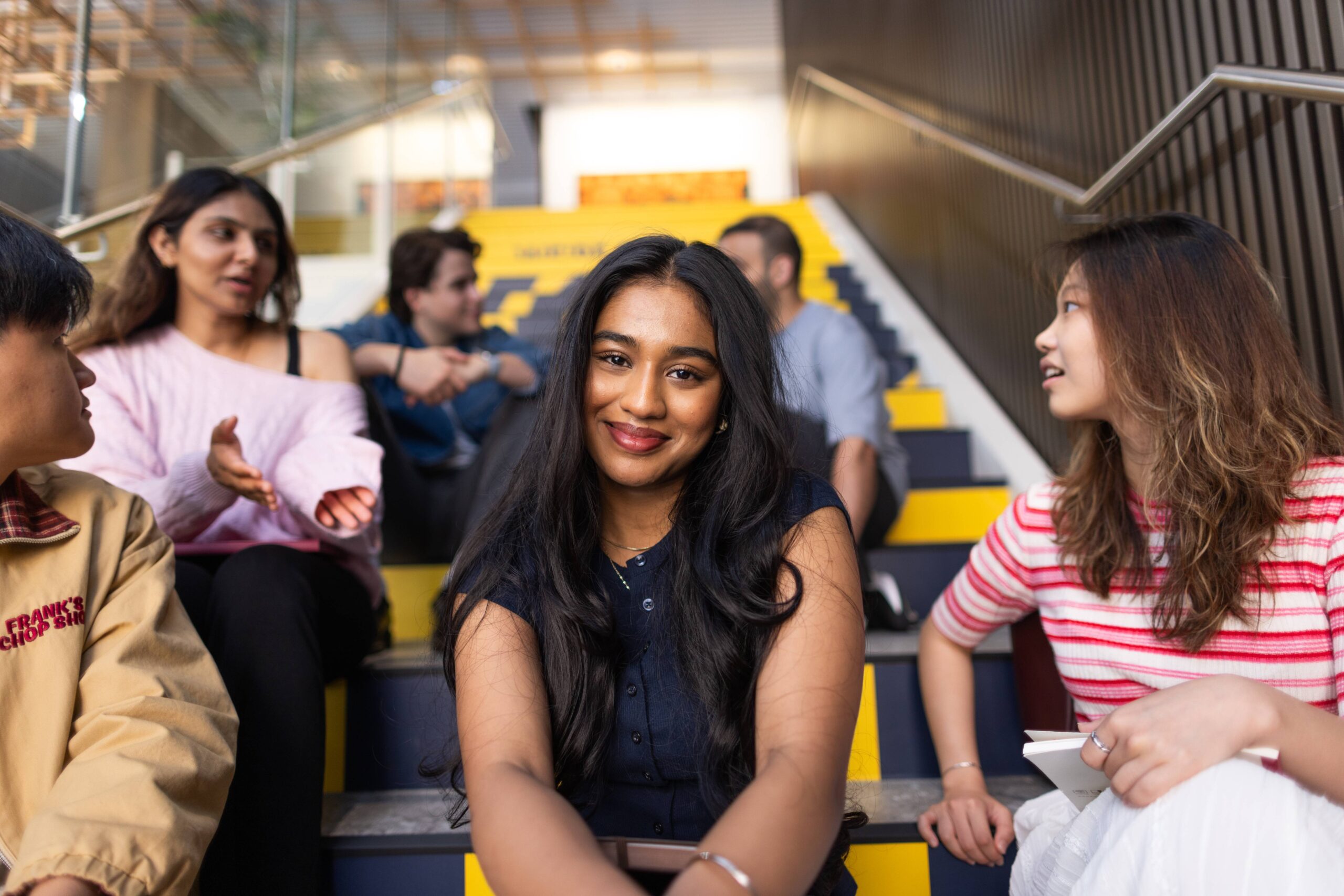 Flinders University Academy student Suhansi sitting on stairs with friends